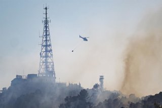 Un helicòpter treballa en les labors d'extinció d'un foc, a 14 d'agost de 2026, a Barcelona, Catalunya (Espanya)