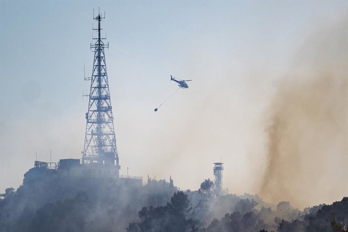 Un helicòpter treballa en les labors d'extinció d'un foc, a 14 d'agost de 2026, a Barcelona, Catalunya (Espanya)