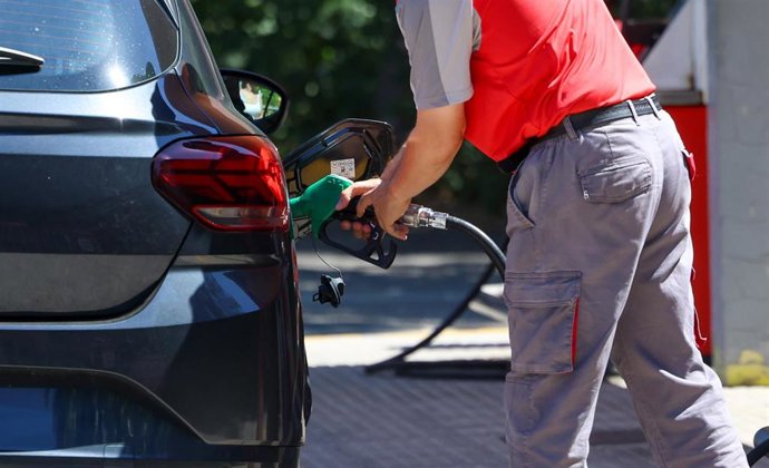 Archivo - Una persona reposta gasolina en un coche
