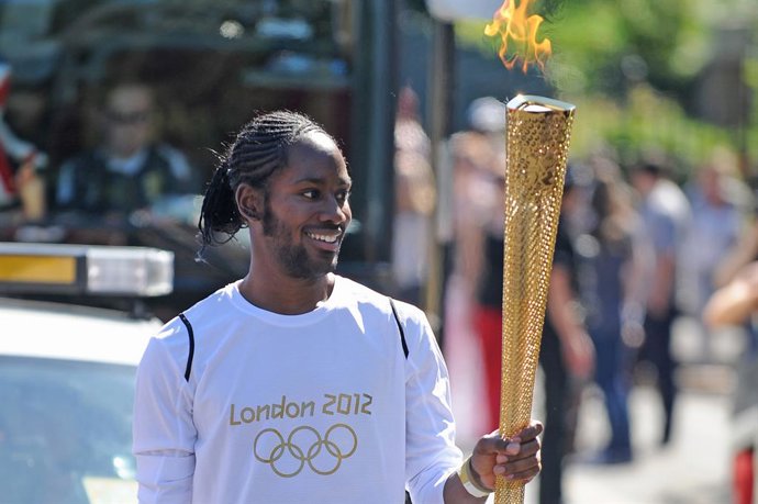 Archivo - FILED - 23 July 2012, United Kingdom, London: FILE PHOTO - Jason Arday carries the Olympic Flame on the Torch Relay leg between Sutton (London Borough) and Merton (London Borough). Photo: Joe Giddens/PA Wire/dpa