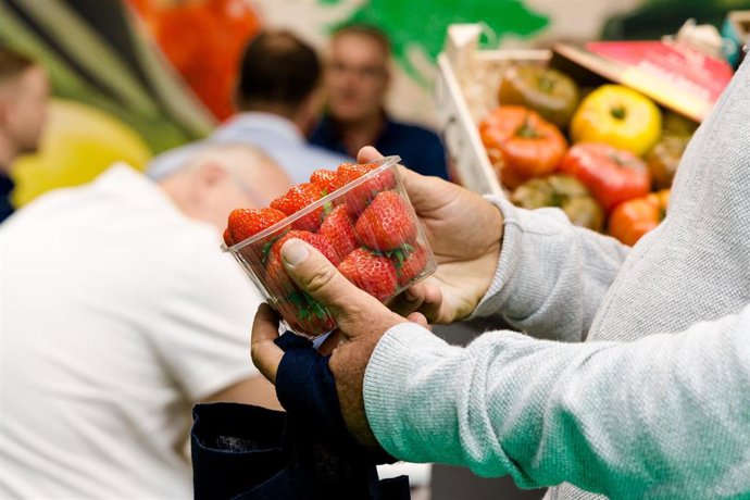 Archivo - Un hombre comprando una cajita de fresas