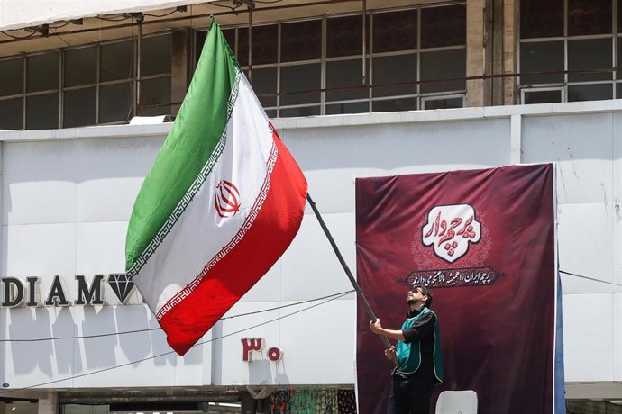 Archivo - Un hombre ondea la bandera de Irán