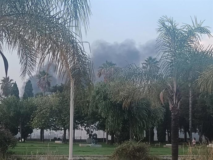 Un incendio ya controlado de dos máquinas del patio de una nave provoca una gran humareda en Huelva