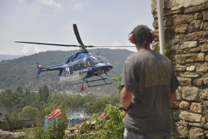 Helicóptero recoge agua de una piscina de plástico en Atarés  durante las labores de extinción de un incendio forestal, a 16 de agosto de 2026, en Las Peñas de Riglos, Huesca, Aragón (España).