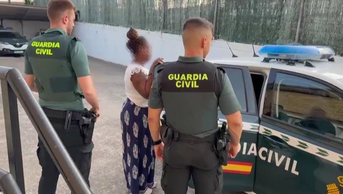 La detenida es conducida a un vehículo policial por agentes de la Guardia Civil