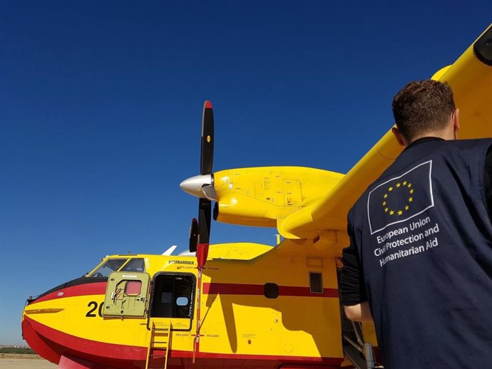 Un miembro del equipo de Protección Civil y Ayuda Humanitaria de la Unión Europea observa un avión anfibio Bombardier CL-415 listo para una misión de extinción de incendios.