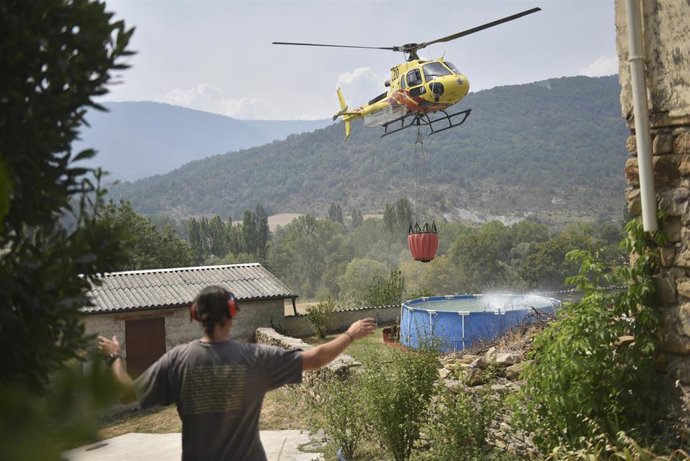 Helicóptero recoge agua de una piscina de plástico en Atarés  durante las labores de extinción de un incendio forestal, a 16 de agosto de 2026, en Las Peñas de Riglos, Huesca, Aragón (España). El operativo desplazado al incendio forestal de Las Peñas de R