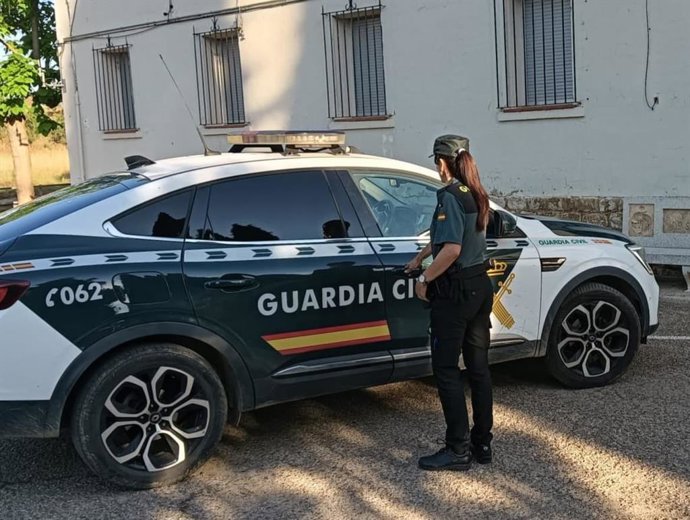 Archivo - Agente de Guardia Civil junto a un coche. Imagen de archivo.