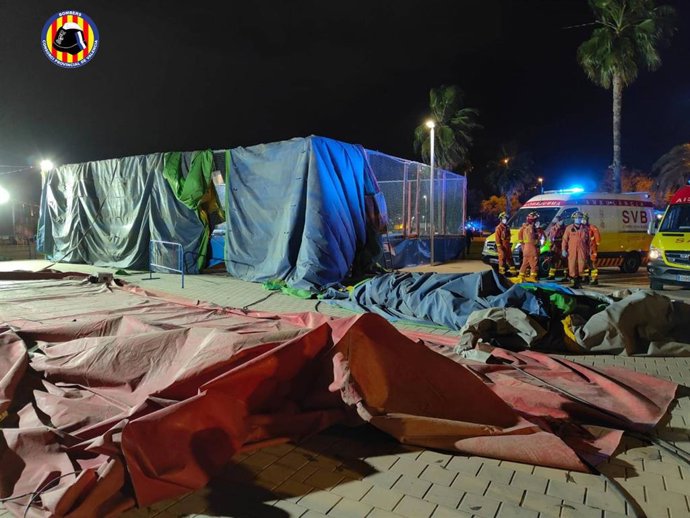 Archivo - Imagen de archivo de bomberos junto al hinchable levantado por el viento en la Feria de Mislata