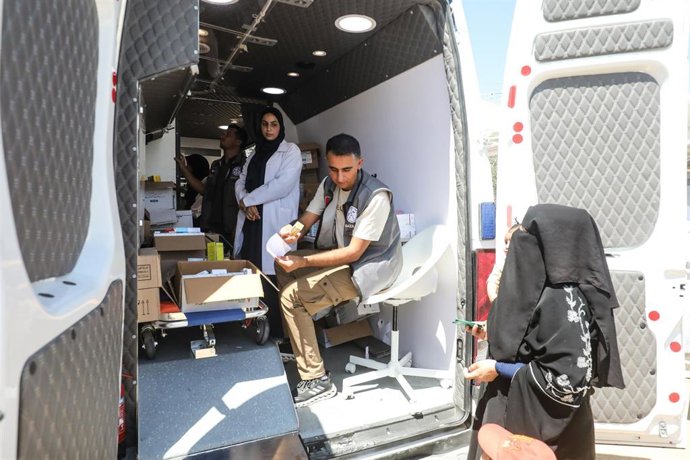Pacientes palestinos, entre ellos niños, reciben tratamiento médico y se les realizan reconocimientos médicos en el interior de una ambulancia que funciona como clínica médica móvil.
