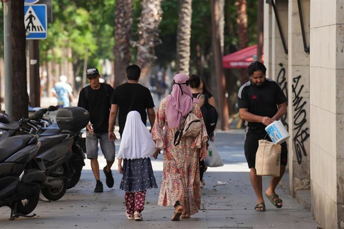 Varias personas caminan por el barrio del Raval de Barcelona