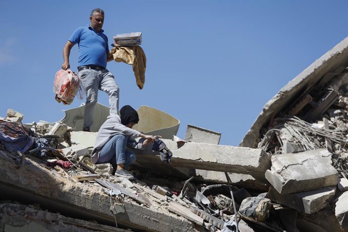 Archivo - Arquivo – 18 de junho de 2026, Distrito de Nabatieh, Sul do Líbano, Líbano: Uma família da cidade de Kfarreman está em meio às ruínas de sua casa destruída, vasculhando os escombros em busca de pertences pessoais, roupas e itens essenciais. A ce