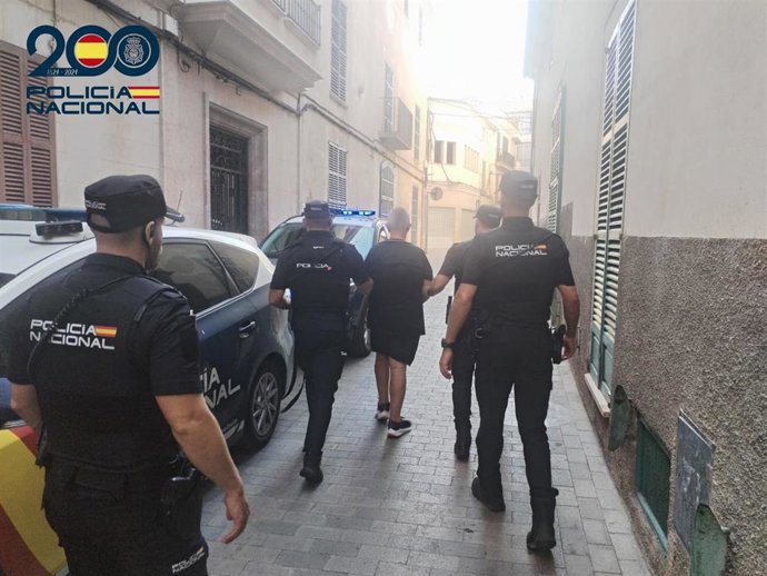 El detenido, de espaldas, escoltado por varios agentes de la Policía Nacional.