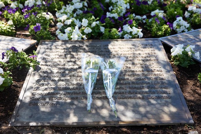 Archivo - Varias personas depositan flores durante el acto de homenaje por el 15º aniversario de la tragedia de Spanair, en el Olivo con las placas de bronce con el nombre de los fallecidos de la Terminal 2, a 20 de agosto de 2023, en Madrid (España). 