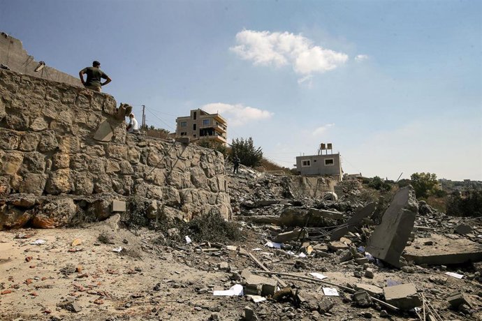 Varias personas inspeccionan daños tras un ataque israelí en Ansar, en el sur de Líbano
