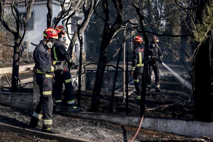 Varios bomberos colaboran en las labores de extinción, a 19 de agosto de 2026, en Aldea del Fresno, Madrid (España).