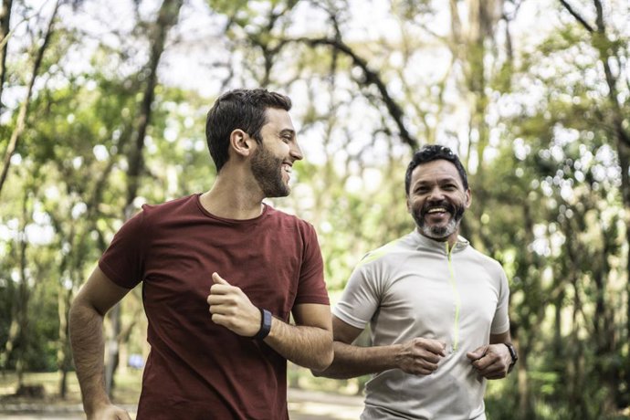 Archivo - Dos amigos corriendo por el parque.