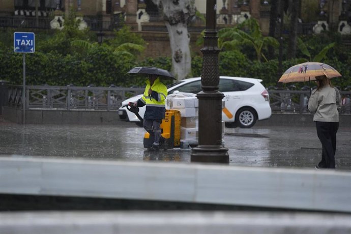 Archivo - Varias personas se protegen de la lluvia con un paraguas. A 03 de marzo de 2025, en Sevilla (Andalucía, España). 