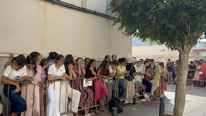 Niños y niñas esperan a las puertas de la Jefatura Superior de Policía de Ceuta para que les registren.