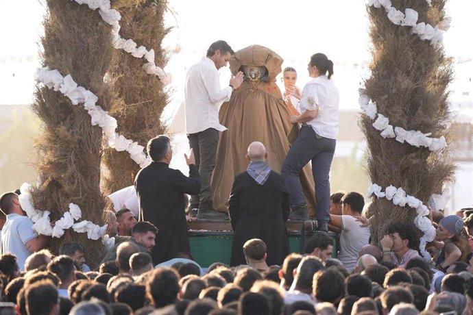 La virgen del Rocío sale a las calles de la aldea del Rocío para ser trasladada al pueblo de Almonte. En la imagen, el momento en el que es cubierta por un guardapolvo