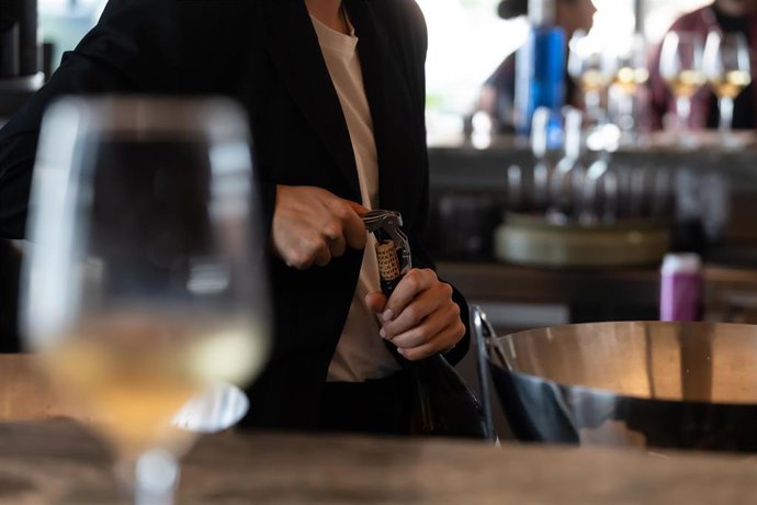 Archivo - Un camarero abre una botella de vino en Barcelona