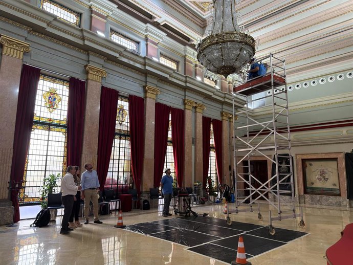 Trabajos de limpieza de la lámpara del Salón de Plenos del Ayuntamiento de Murcia