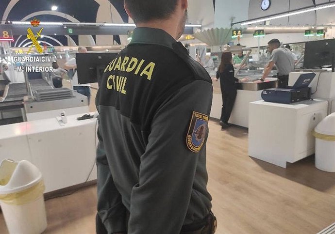 Archivo - Un agente de la Guardia Civil, en el aeropuerto de Sevilla en una foto de archivo.