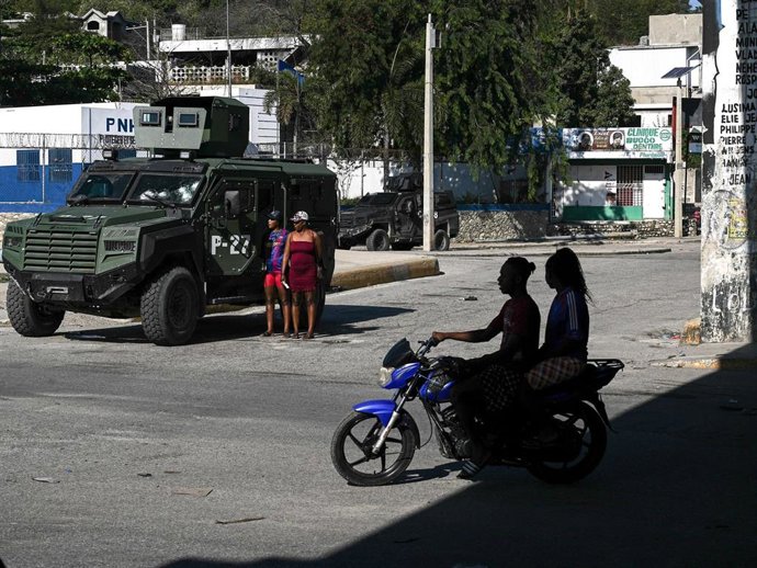 Archivo - Una motocicleta pasa junto a un vehículo militar blindado cerca del cruce del aeropuerto, más conocido como el cruce de Rezistans, en Puerto Príncipe, capital de Haití