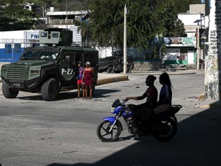 Archivo - February 17, 2026, Port Au Prince, Haiti: A motorcycle passes an armored military vehicle near the airport intersection, better known as the Rezistans intersection, in Port-au-Prince, capital of Haiti, as the country, plunged into a major humani