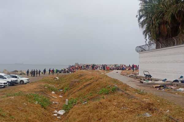 La Policía escolta a los servicios de limpieza en la playa El Trampolín de Ceuta, donde volvieron cientos de inmigrantes