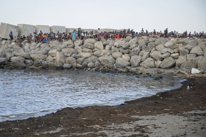 Varios inmigrantes acampados en la playa del Trampolín, a 20 de agosto de 2026, en Ceuta (España).