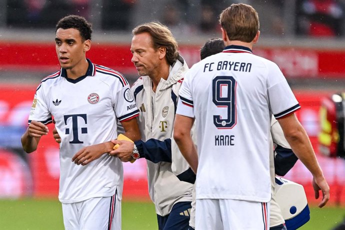18 August 2026, Baden-Wuerttemberg, Heidenheim: Bayern Munich's Jamal Musiala (L) leaves the field with assistance during the pre session friendly soccer match between 1. FC Heidenheim and FC Bayern Munich. Photo: Harry Langer/dpa - WICHTIGER HINWEIS: Gem