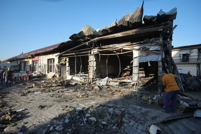RÚSSIA, DONETSK – 19 DE AGOSTO DE 2026: Homens removem os escombros dos pavilhões do mercado danificados durante a madrugada por um ataque com drone ucraniano no distrito de Kalininsky