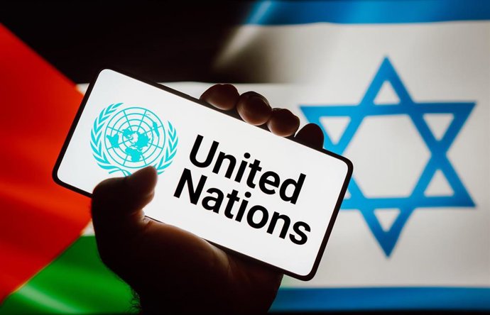 Archivo - Ilustración: Logotipo de Naciones Unidas en la pantalla de un teléfono móvil, sobre las banderas de Palestina e Israel