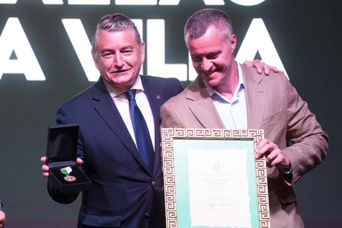 El vicepresidente primero y consejero de Presidencia, Sanidad y Emergencias, Antonio Sanz recibe el galardón de manos del alcalde de Grazalema, Carlos Javier García. 