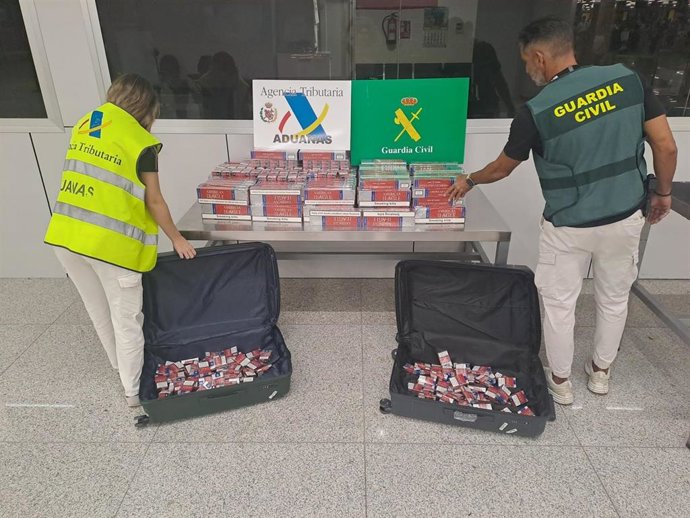 Un agente de la Guardia Civil y otro de Vigilancia Aduanera, junto con el tabaco intervenido a la joven.