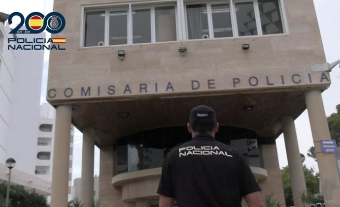 Un agente de la Policía Nacional, de espaldas y frente a la comisaría de la Playa de Palma.