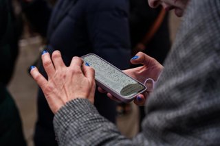 Archivo - Persona consulta un móvil en la plaza de Callao, a 17 de enero de 2026, en Madrid (España). 