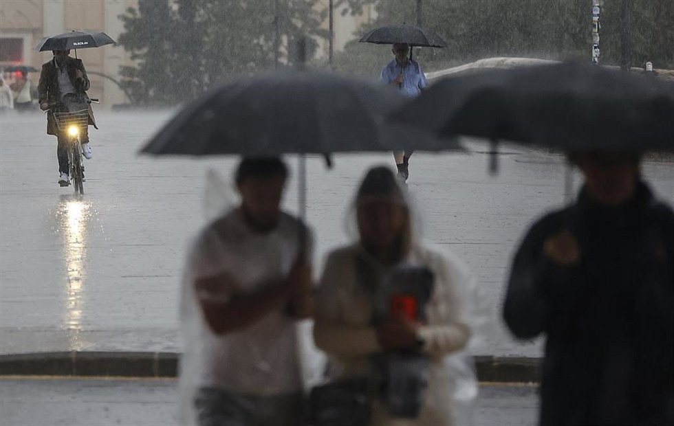 Archivo - Varias personas con paraguas bajo la lluvia, en imagen de archivo. 