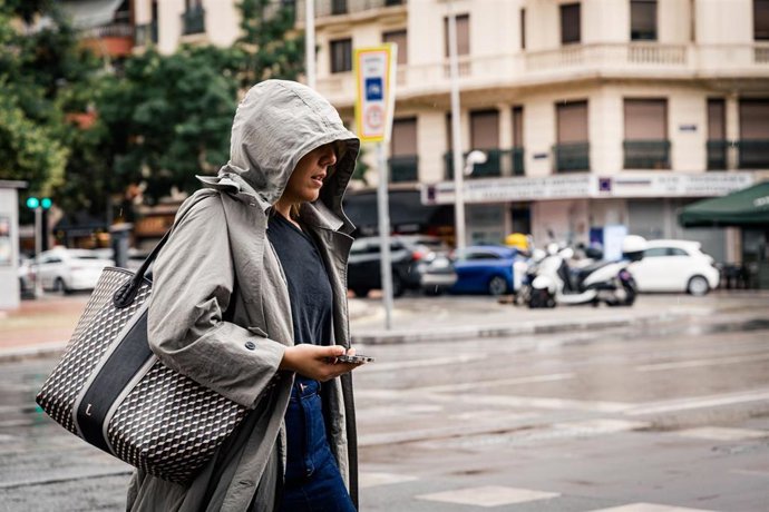Archivo - Una mujer pasea bajo la lluvia, a 25 de junio de 2026, en Madrid (España). 