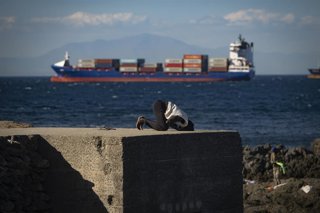Un inmigrante reza en una playa, a 21 de agosto de 2026, en Ceuta (España). Ceuta sigue afrontando una grave crisis humanitaria después de la histórica entrada masiva de más de 70.000 migrantes a nado por el Tarajal durante los días 30 y 31 del pasado mes