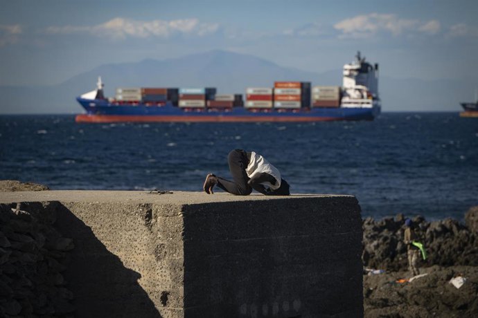 Un inmigrante reza en una playa, a 21 de agosto de 2026, en Ceuta (España). Ceuta sigue afrontando una grave crisis humanitaria después de la histórica entrada masiva de más de 70.000 migrantes a nado por el Tarajal durante los días 30 y 31 del pasado mes