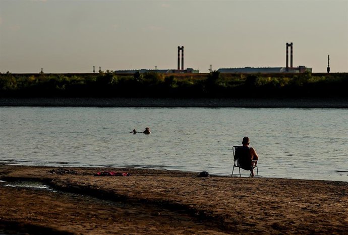 Archivo - Un hombre está sentado a orillas del Danubio, con la central nuclear de Paks al fondo, cerca de Dunaszentbenedek, Hungría