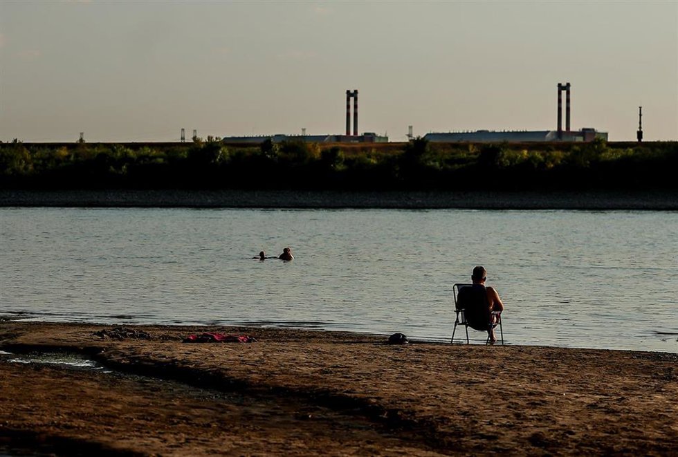 Archivo - Un hombre está sentado a orillas del Danubio, con la central nuclear de Paks al fondo, cerca de Dunaszentbenedek, Hungría