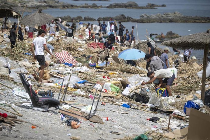 Algunos migrantes vuelven a la playa del Trampolín tras su desalojo, a 20 de agosto de 2026, en Ceuta (España). 
