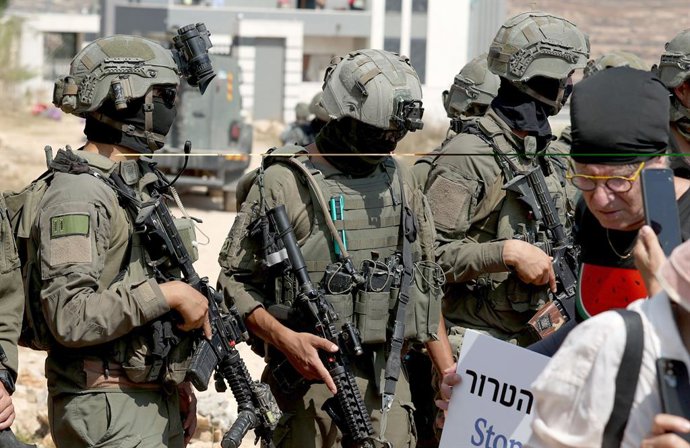 14 de agosto de 2026, Nablus, Cisjordânia, Palestina: Soldados israelenses são vistos em frente à entrada de uma residência palestina sitiada por colonos israelenses na vila de Qusra. As forças israelenses atacaram os colonos que cercavam as residências p