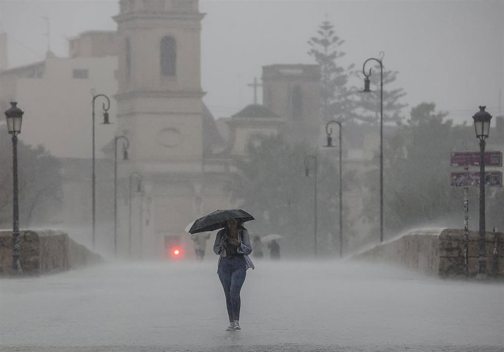 Archivo - Una persona camina con un paraguas bajo la lluvia, en imagen de archivo. 