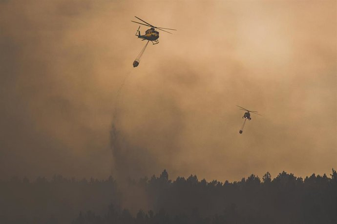 Dos helicópteros trabajan en las labores de extinción, a 14 de agosto de 2026, en Lousame, A Coruña, Galicia (España). 