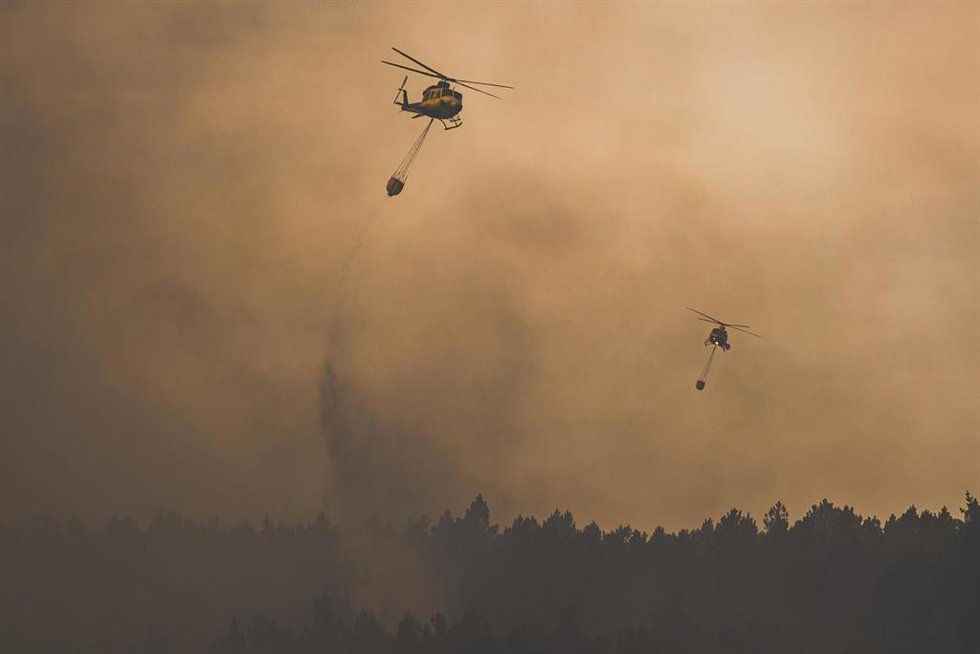 Dos helicópteros trabajan en las labores de extinción, a 14 de agosto de 2026, en Lousame, A Coruña, Galicia (España). 