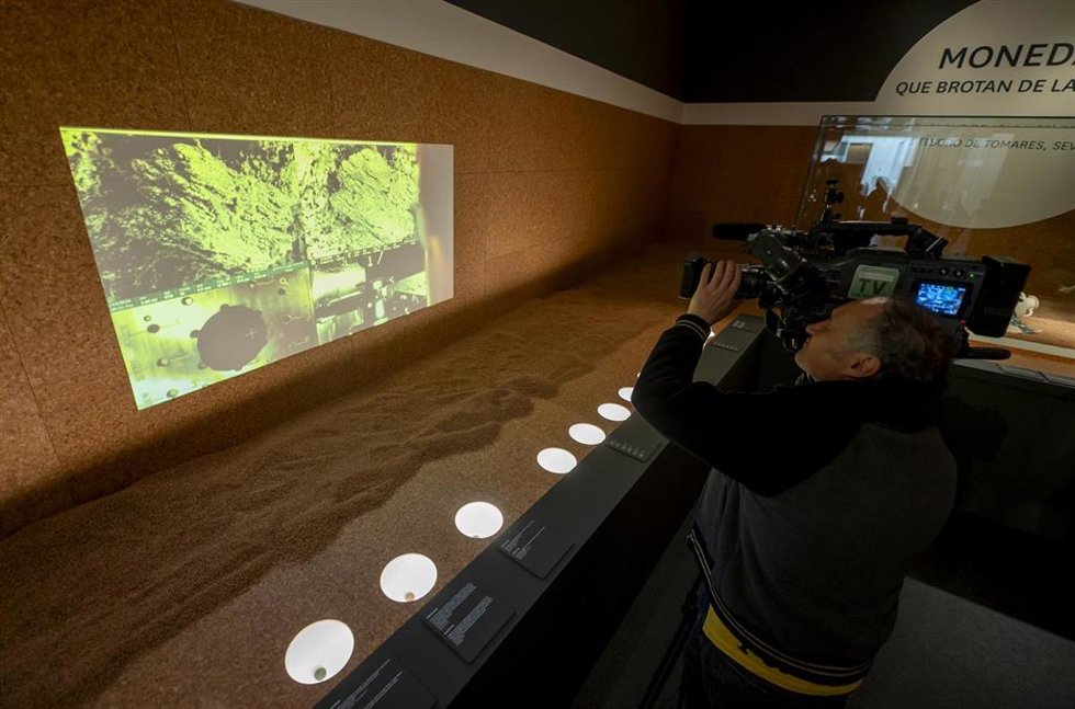 Archivo - Un hombre graba durante la exposición temporal 'Monedas que brotan de la tierra. El Tesoro de Tomares, Sevilla', en el Museo Arqueológico Nacional (MAN), a 12 de mayo de 2025, en Madrid (España). 